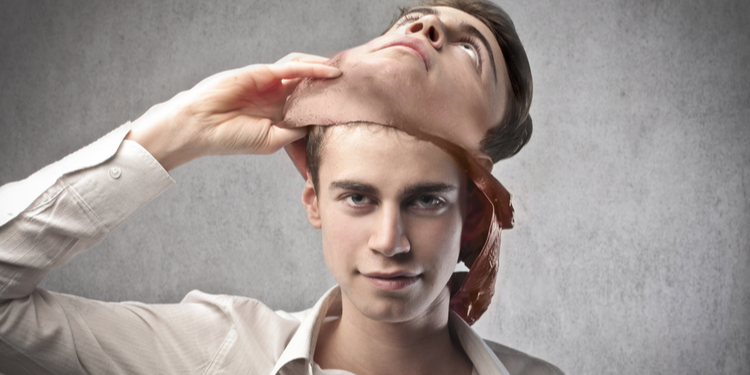 Sinister young man removing realistic but fake facemask