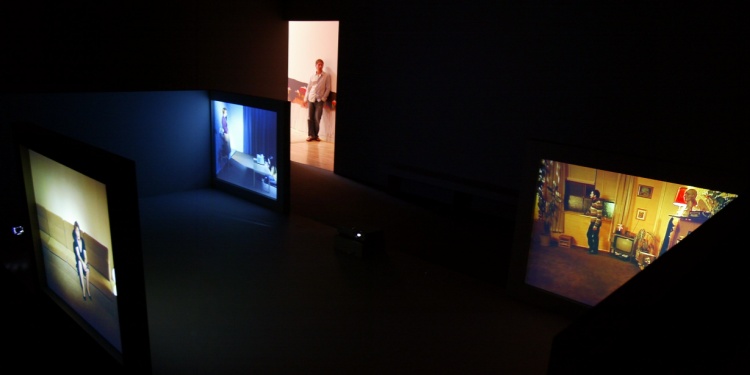 A colorful artist installation with people in separate rooms.