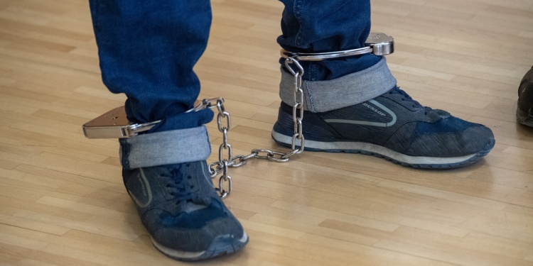 A defendant wearing an ankle bracelet monitor.