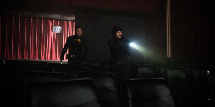 Two FBI agents shining a light in a dark investigation.