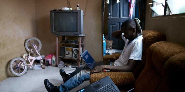 A Ghanian hacker on a computer.