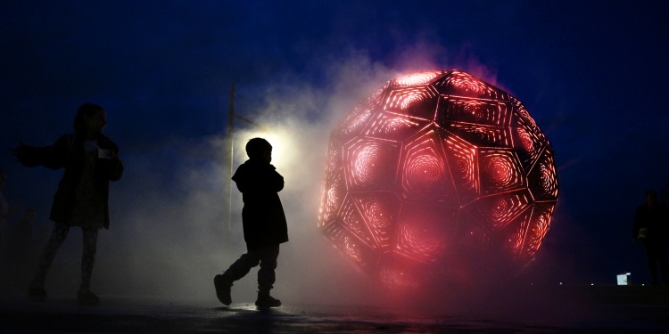 A red spherical UFO surrounded by shadows.