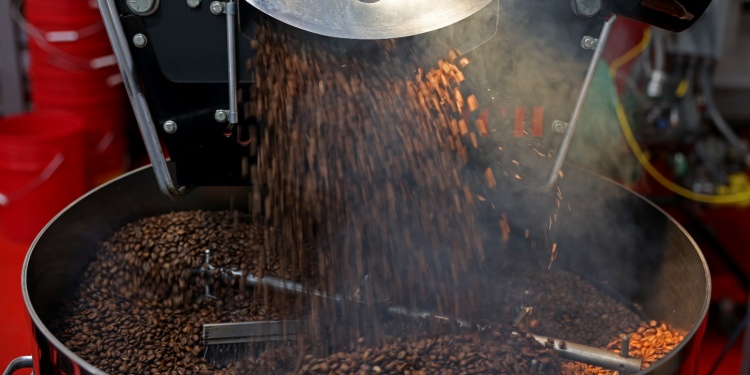 An industrial coffee grinder, full of beans.