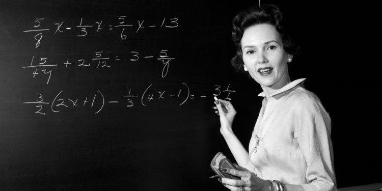 A retro schoolteacher with algebra on the blackboard.