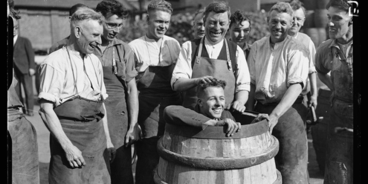 A young man actually in the bottom of a barrel.