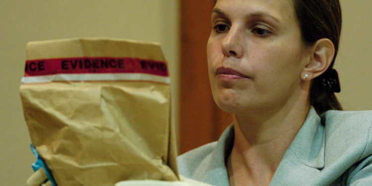 A detective holding an evidence bag.