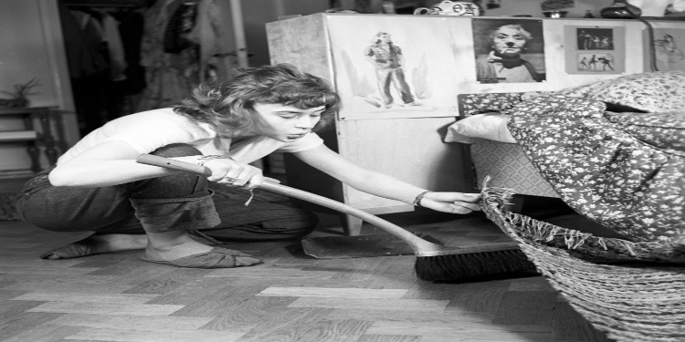 Black and white photo of a housewife sweeping