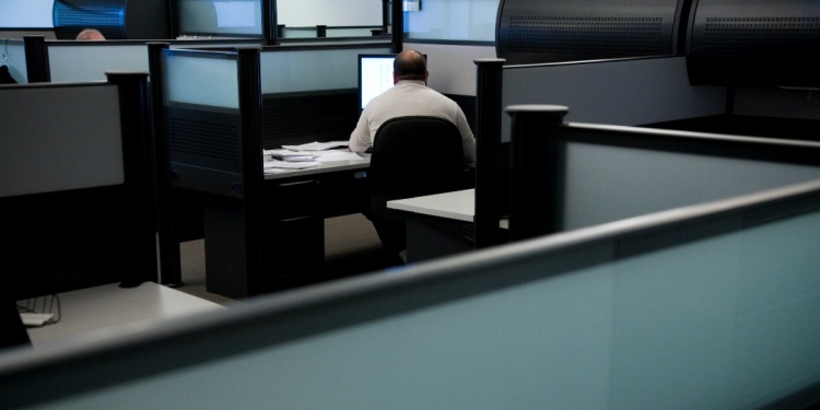 An office worker snowed under in his cubicle.