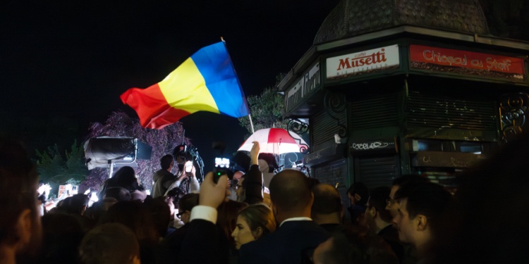 Romanian citizens celebrating the election results at night.