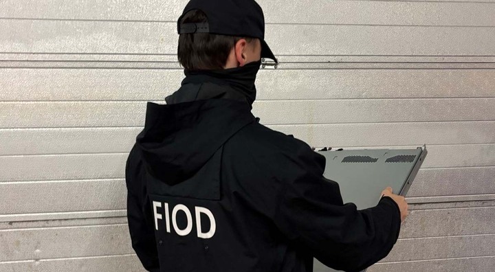man in black jacket, black had, hold paper, white letters FIOD