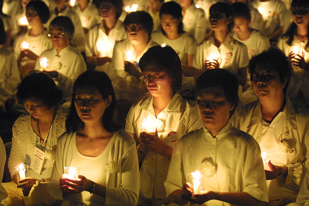 Believers holding candles in Falun Gong rally