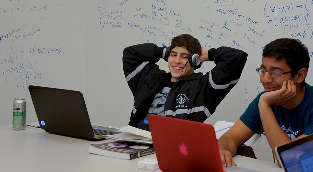 Two male students using laptops