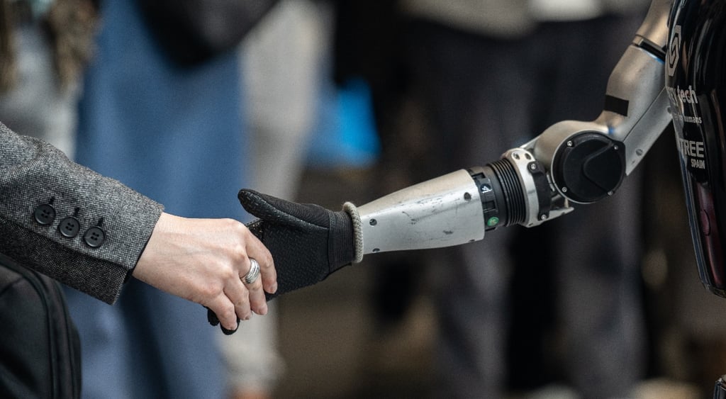Human person shaking hands with Unitree humanoid robot
