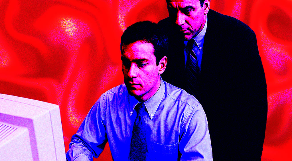 Manager watching over worker looking at screen