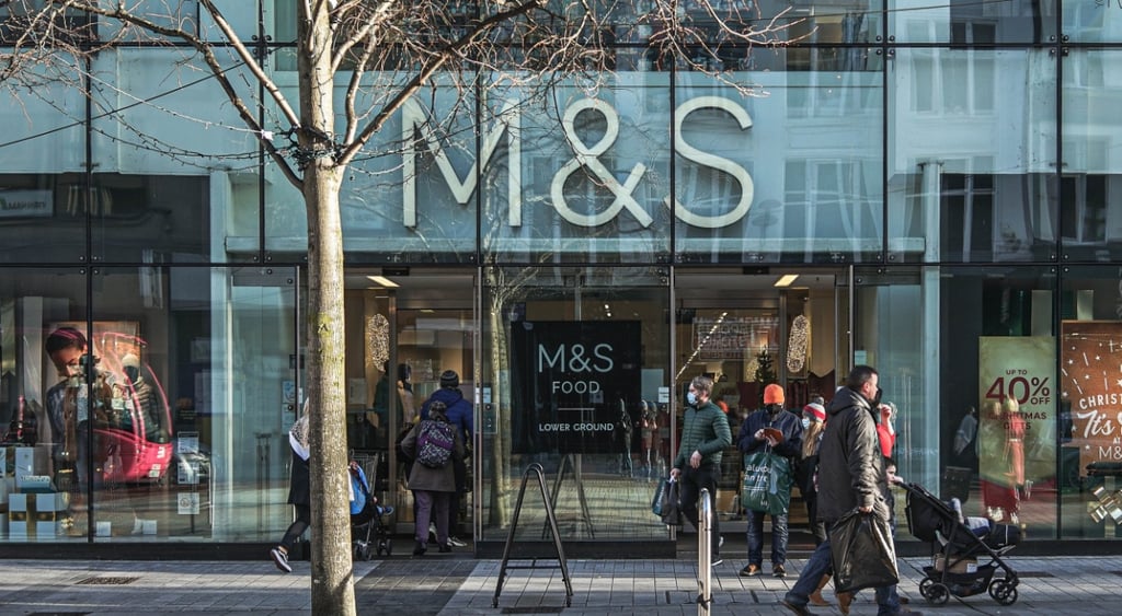 m&s store, big front sign, people on the street, a tree