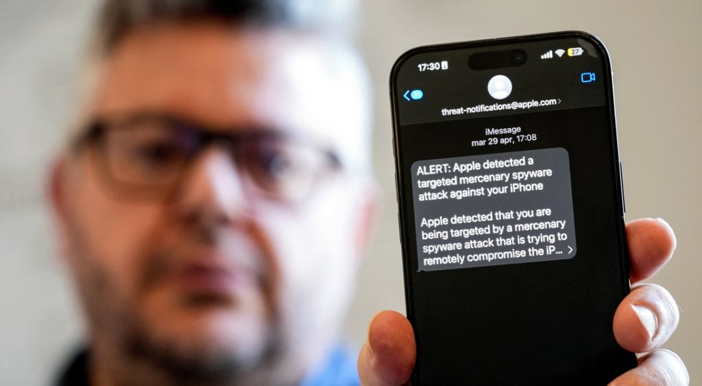 blurry mans face with glasses and phone in focus showing alert