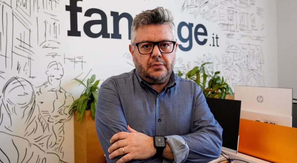 italian man with glasses and dark blue shirt with arms crossed and glasses, grey hair