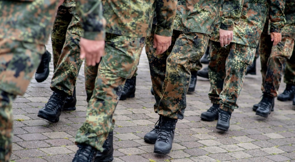 black army boot, army camouflage throusers, brown tile pavement