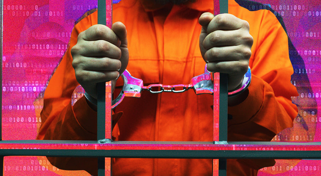 Handcuffed man behind the bars in jail; criminal; cybercriminal