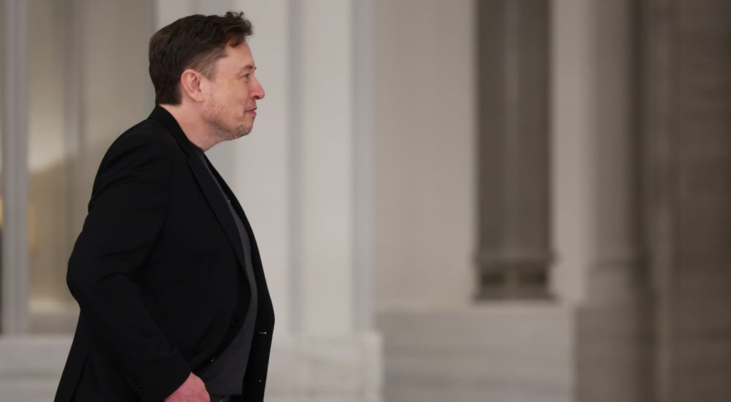 elon musk in black suit seen from profile