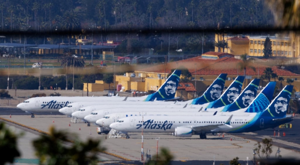 five alaska airline white planes, blue tails palm trees
