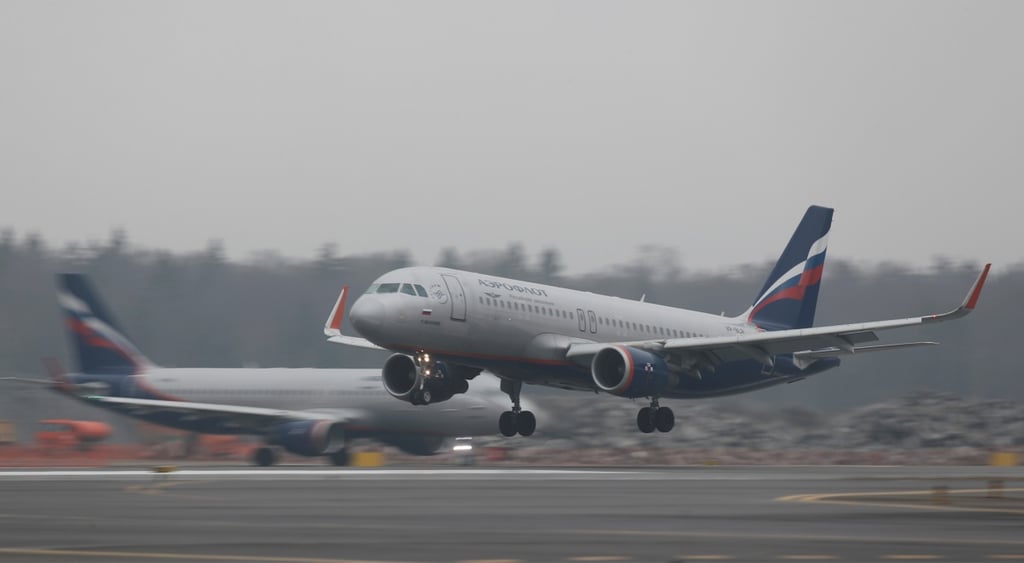 white plane with russian white blue and red flag on tail