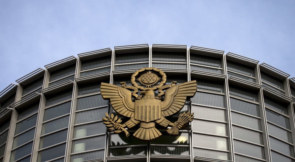 us federal court grey glass round building, bronze eagle, shield, laurel branch, blue sky