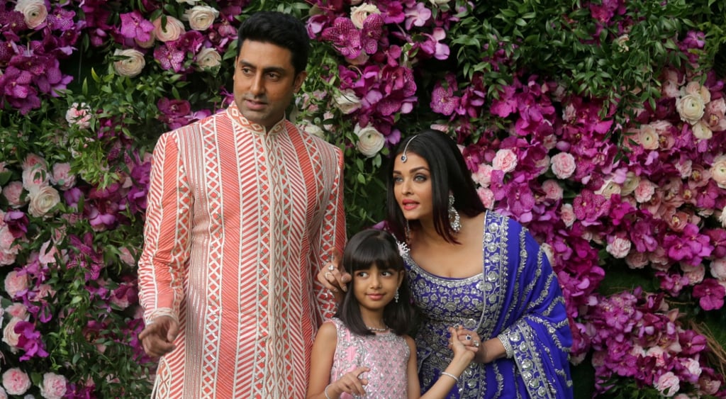 indian man and woman in pink and white suit, blue sari, girl in pink silver dress