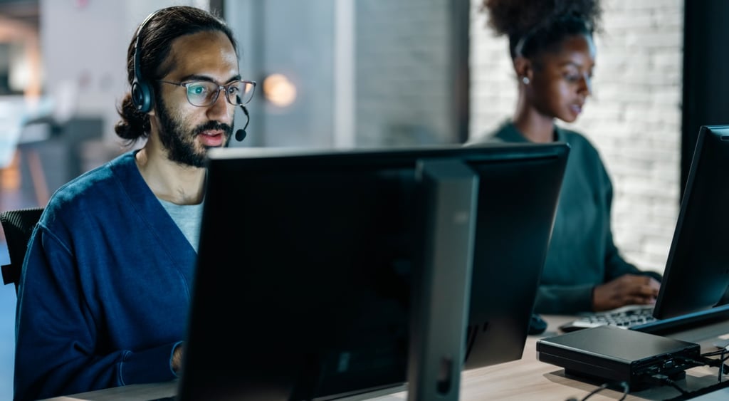 Two workers at call center helping with online assistance