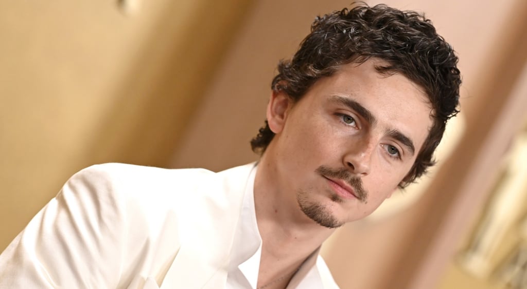 Timothee Chalamet in white suit, little moustache, little chin beard, no tie