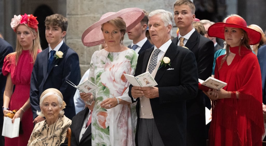 belgium royal family, red dress, red hat, old man in tux, woman in white floral dress,