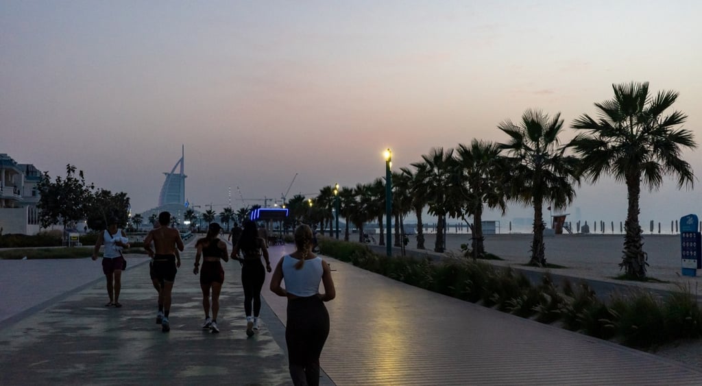 People running along the Dubai promenade.