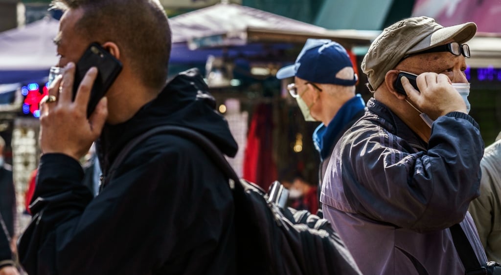 pedestrians on busy hong kong street, asian men speaking on smartphones, facial masks