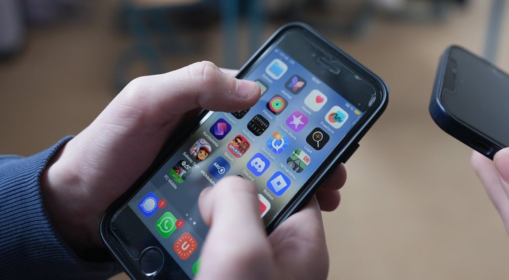 Person holds iPhone in their hands with app screen visible