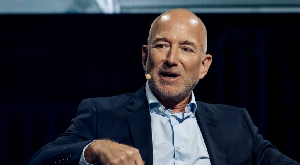 jeff bozos, blue shirt, shiny bald head, little grey beard