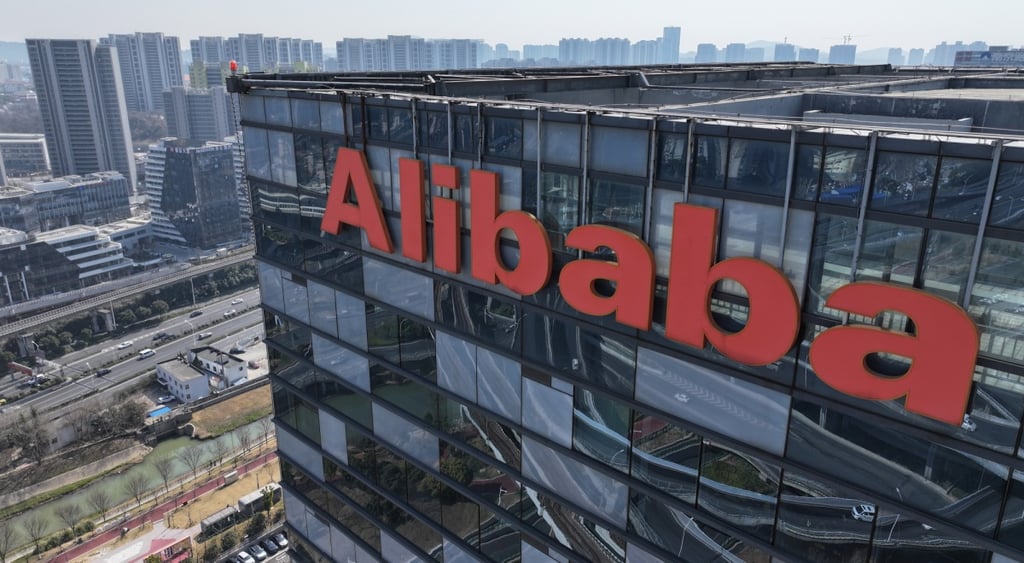 alibaba orange logo on top of dark glass building