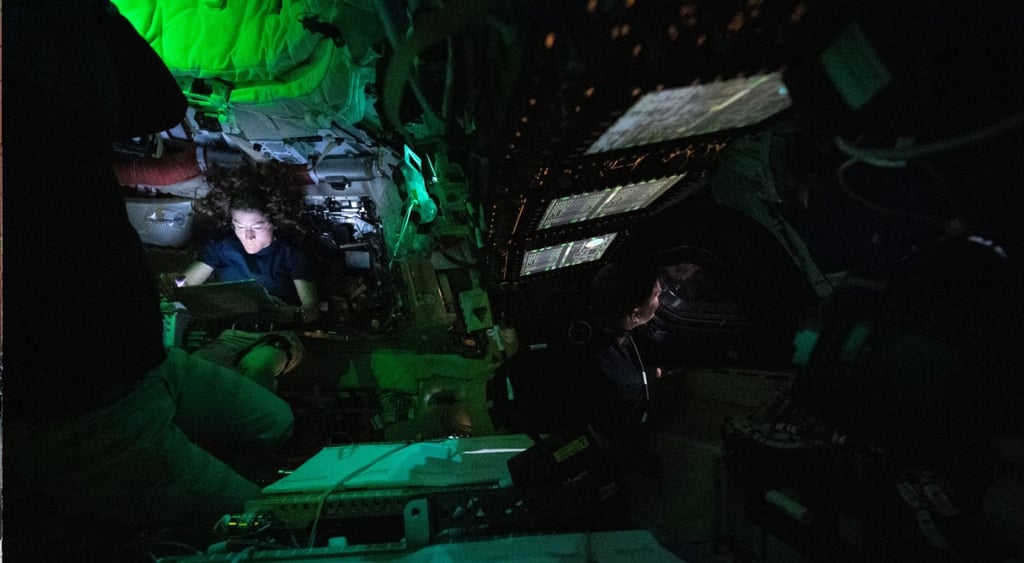 woman illuminated in green light in spacecraft