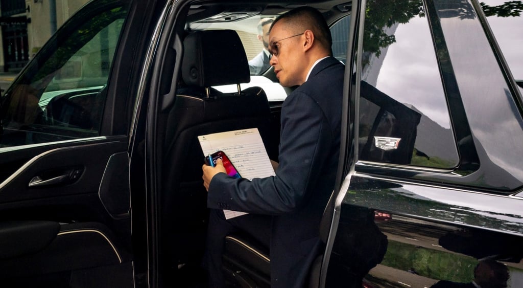 Changpeng Zhao gets to fancy black car, black sunglasses, white paper