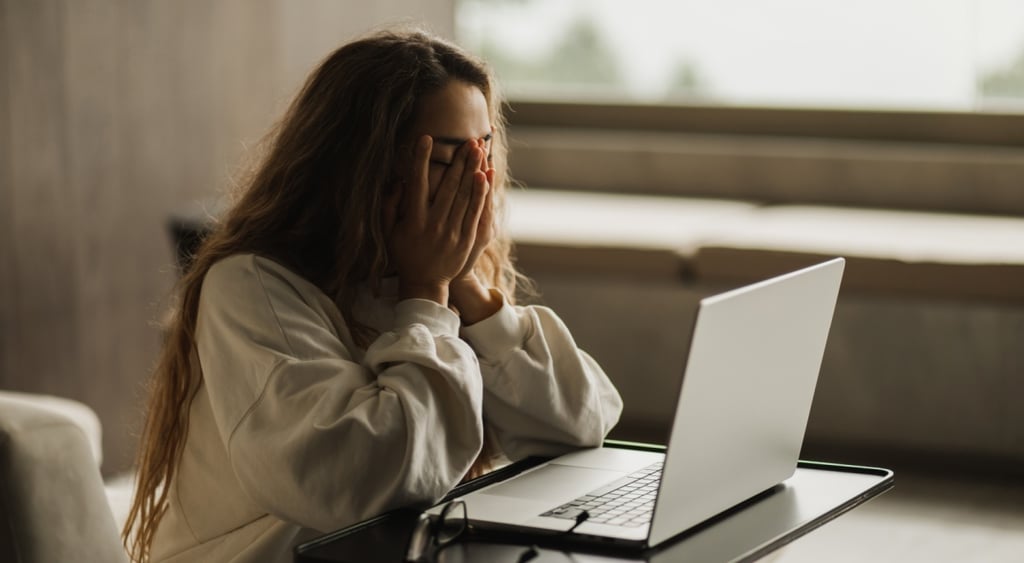 white woman covering her face, mental distress, long loose hair, white laptop, ivory jumper