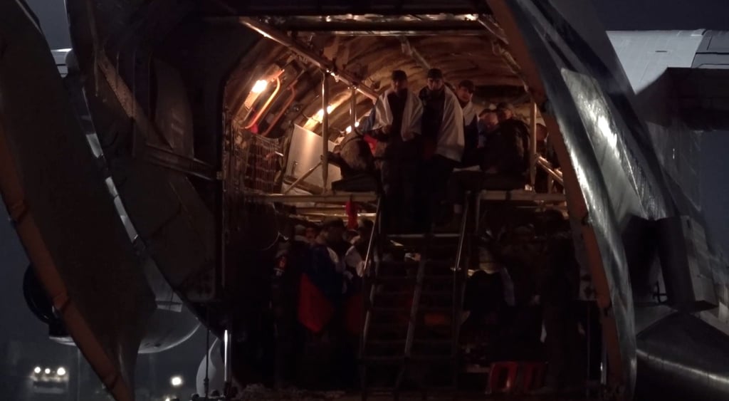 men in war uniformans and russian flags on their shoulders are departing from bus