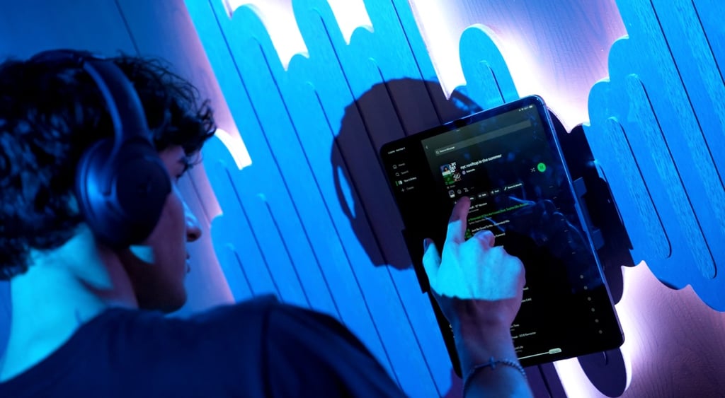 young white man ,dark hair, black headphone, dark screen Spotify pad, blue music waves .
