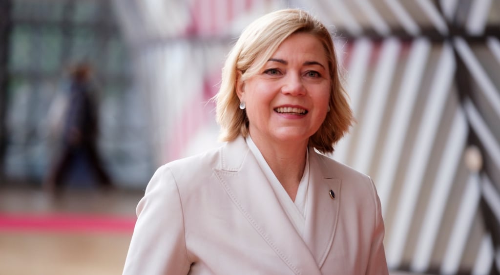 Henna Virkkunen, middle aged white woman, shoulder length blonde hair, white suit, smile
