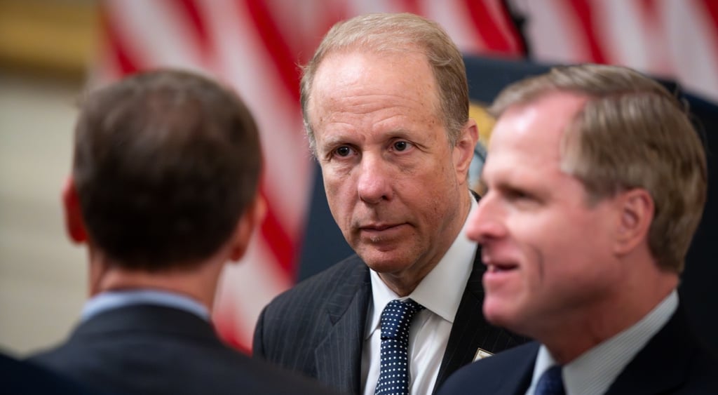 Steve Feinberg, bald white man, black suit ,white shirt, usa flag white and red stripes