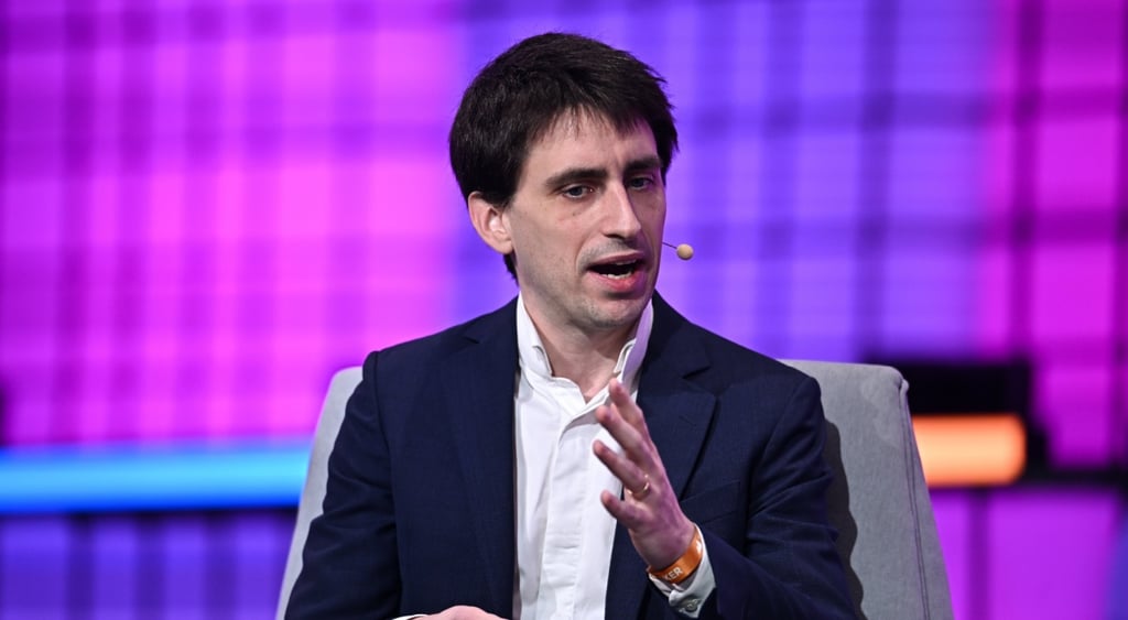Theau Peronnin, black suit, white shirt, no tie, young white man, black hair, purple background