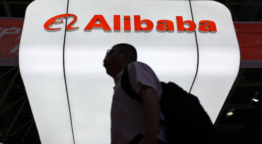 Man walks past Alibaba logo