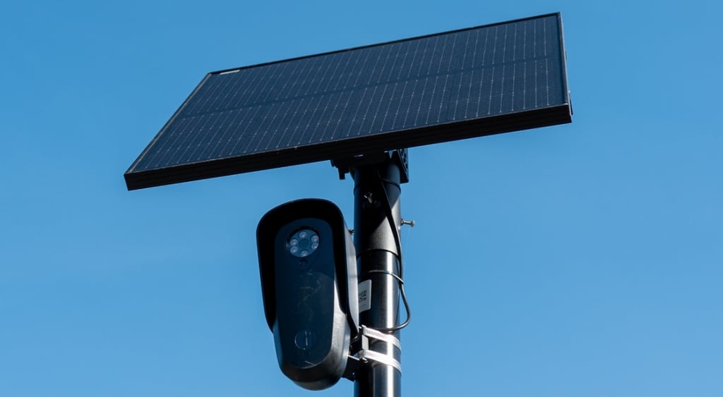 black flock camera, clear blue sky, black solar panel