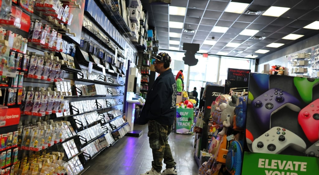 gamestop shop, shelves with computer games, fat man in hat, jeans
