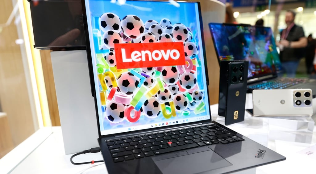 black lenovo laptop, screen twice in size than the bottom, lots of small footballs, red button
