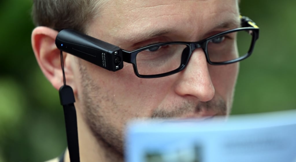 smart glasses, white man, short beard, green outdoors