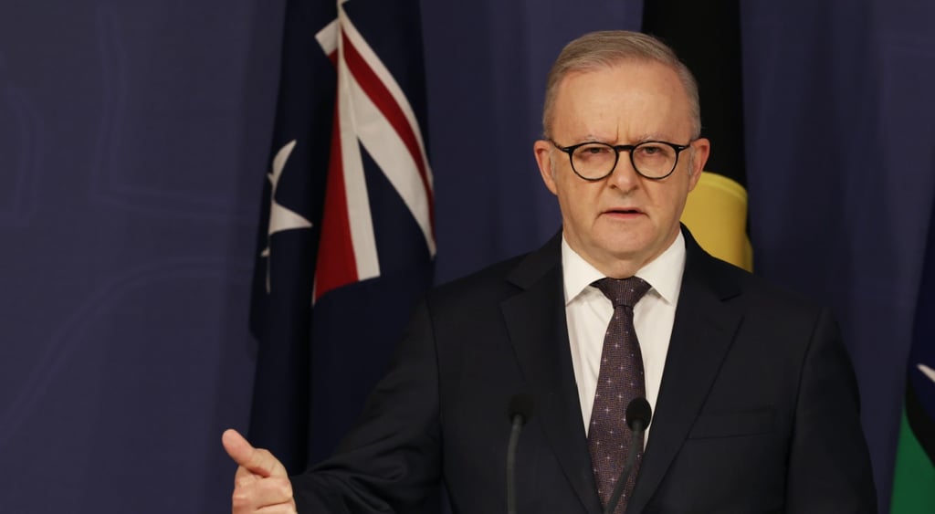 Anthony Albanese, australia flag, thumbs up, white jacket, white collar shirt, dark tie, glasses